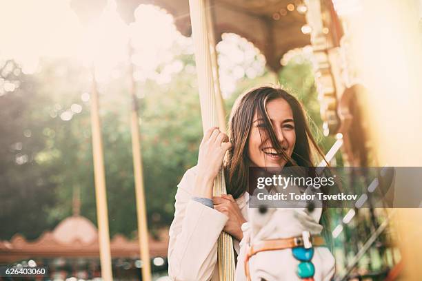 woman on a roundabout - holding horse stockfoto's en -beelden