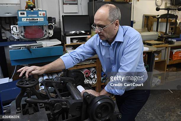 Bob Covington, the Head of the Bindery, operates a manual machine to round the spine of a book that's being prepared at Collis Bird and Withey...