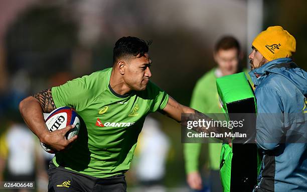 Israel Folau of Australia hands off Nathan Grey, Defence Coach of Australia during an Australia training session at Harrow School on November 29,...