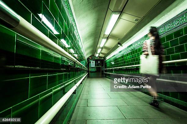 verschwommene bewegung der jungen frau in londoner u-bahn-tunnel - londoner u bahn stock-fotos und bilder