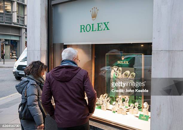 Middle aged couple look at Rolex watches displayed in the window of a high class watch store in Fenchurch Sreet on November 22, 2016 vin London,...