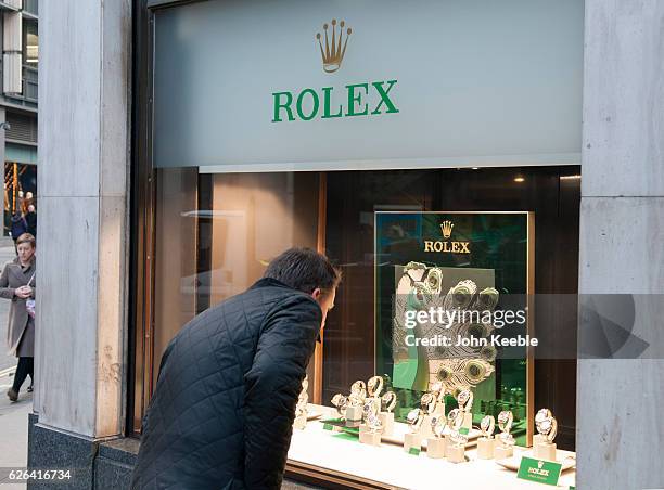 Business man looks at Rolex watches displayed in the window of a high class watch store in Fenchurch Sreet on November 22, 2016 vin London, United...