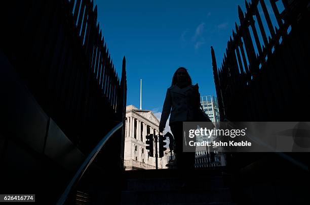 General view of the Bank of England from the entrance of Bank tube station with a silhouette of a business person on a bright blue sky day on...