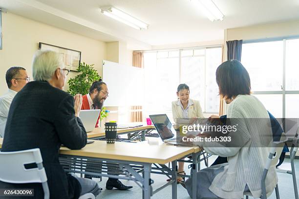 fermale teacher with adult students in community college - community center stock pictures, royalty-free photos & images