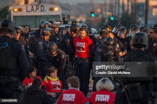 Striking McDonald's restaurant employees sitting in an intersection are arrested after walking off the job to demand a $15 per hour wage and union...