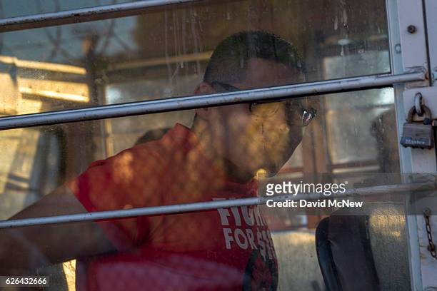 Striking McDonald's restaurant employees are put onto buses after being arrested while sitting in an intersection after walking off the job to demand...