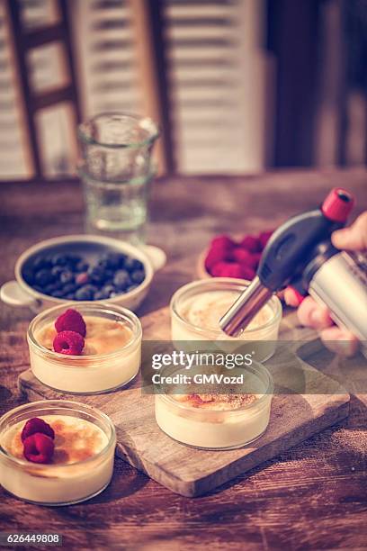 preparing homemade creme brulee with berries - creme brulee stock pictures, royalty-free photos & images