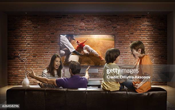 family with children watching baseball game on tv - baseball mom stockfoto's en -beelden