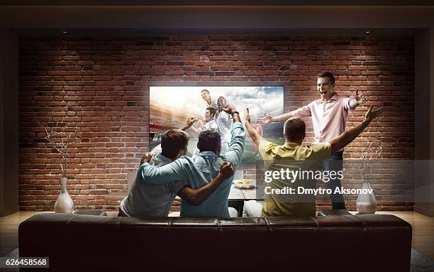 students watching soccer game at home - people watching tv stock pictures, royalty-free photos & images