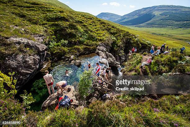 tourists swim in stream on skye, scotland - skye stockfoto's en -beelden