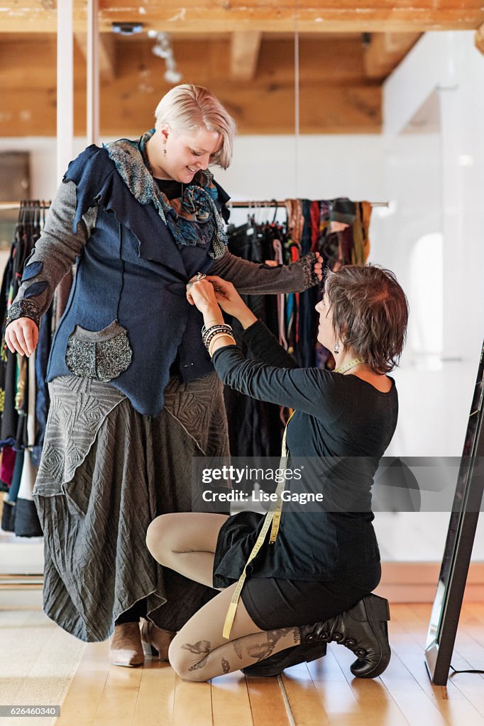Diseñador de moda que toma la medición del cliente en la boutique de ropa