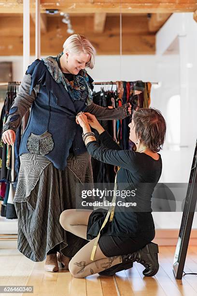 fashion designer  taking customer measurement in clothing boutique - lise gagne stock pictures, royalty-free photos & images