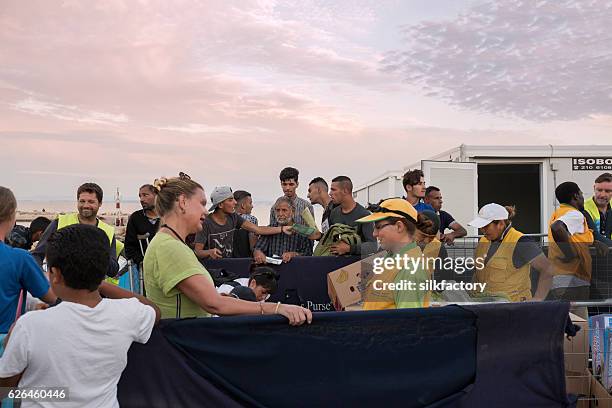 sunset at greek refugee camp as volunteers start serving supper - quiosque stock pictures, royalty-free photos & images