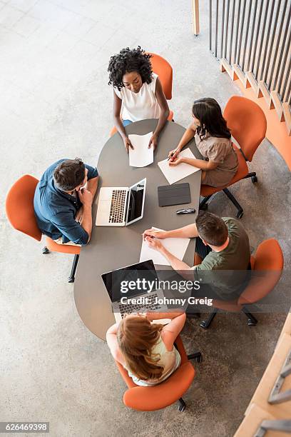 vista general de cinco empresarios en la mesa en la reunión - tormenta de ideas fotografías e imágenes de stock