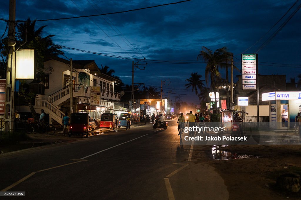 Street scene at dusk with lit up shops taken in Ahangama, Sri Lanka