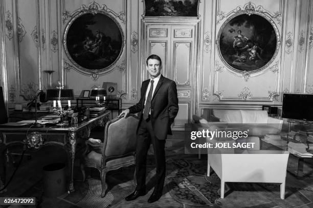 French Prime Minister Manuel Valls poses during a photo session in his office at the Hotel de Matignon in Paris on November 24, 2016. / BLACK AND...