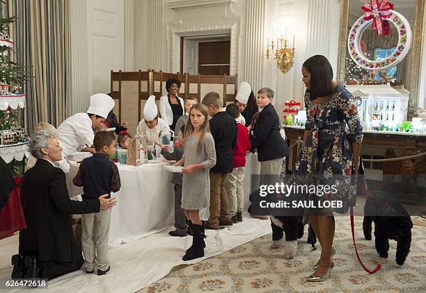 First Lady Michelle Obama, with the First Family's dogs Sunny and Bo, greets children of military families as they make holiday crafts and treats...