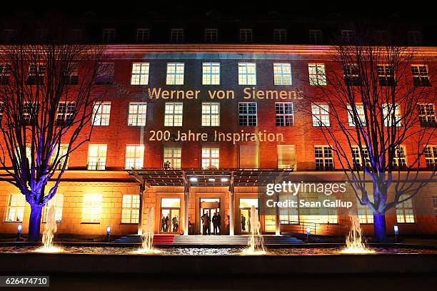 The Berlin headquarters of Siemens AG are seen illuminated with an image of the company's founder, Werner von Siemens, during his 200th birthday...