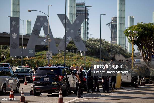 Police officers stand watch as fast-food, airport, home care and other workers protest to call for a higher minimum wage at Los Angeles International...