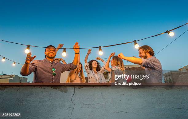 rooftop party scene, dancing - rooftop party stock pictures, royalty-free photos & images