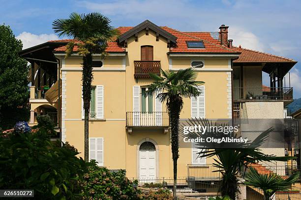 splendida villa con esterno in stucco giallo e tetto rosso, italia - baveno foto e immagini stock