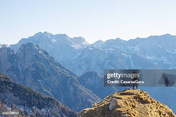 alpinist enjoying the view over the mountains in the alps - guy on top of mountain stock pictures, royalty-free photos & images