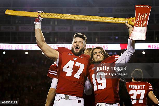Vince Biegel and Leo Musso of the Wisconsin Badgers hoist the Paul Bunyan's Axe trophy after beating the Minnesota Golden Gophers 31-17 at Camp...