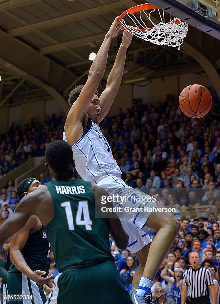 Chase Jeter of the Duke Blue Devils dunks over Eron Harris of the Michigan State Spartans during the game at Cameron Indoor Stadium on November 29,...