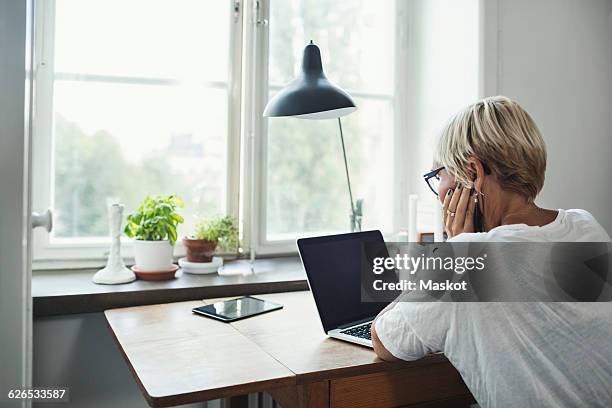 rear view of industrial designer using laptop at home office - back stock pictures, royalty-free photos & images