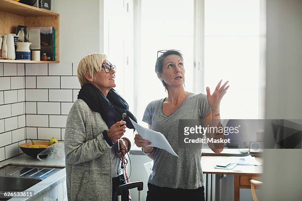 industrial designer explaining project to colleague at domestic kitchen - draft combine 2015 stock pictures, royalty-free photos & images