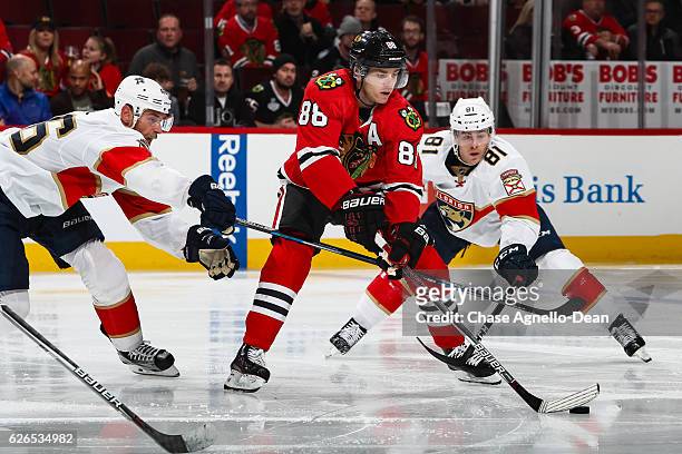 Patrick Kane of the Chicago Blackhawks grabs the puck against Jakub Kindl and Jonathan Marchessault of the Florida Panthers in the second period at...