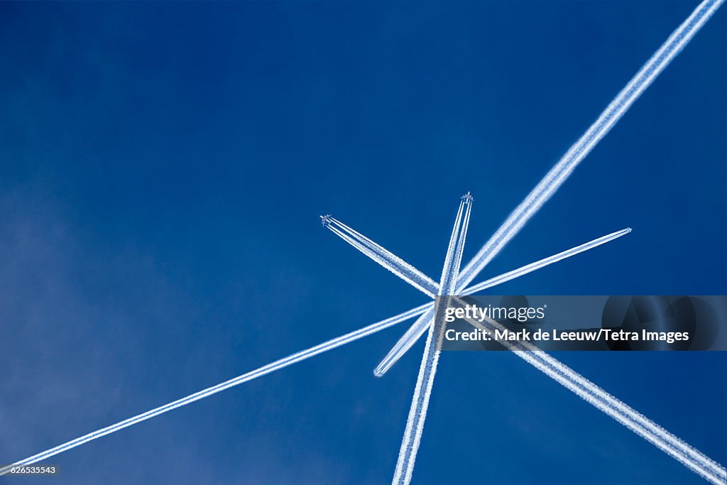 Austria, Maria Alm, Crossed vapor trails of airplanes in blue sky