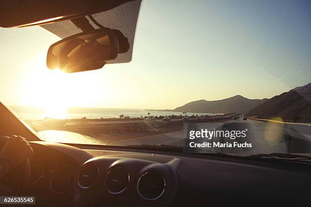 young woman on the road driving pacific coast highway at sunset, california, usa - windschutzscheibe stock-fotos und bilder