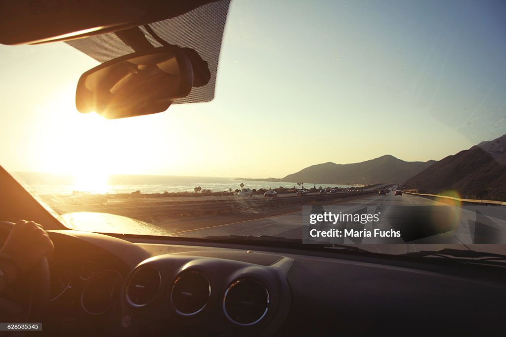 Young woman on the road driving pacific coast highway at sunset, California, USA