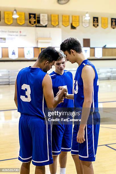 diverso equipo de baloncesto de la escuela secundaria durante un amontonamiento del equipo - tiempo-muerto fotografías e imágenes de stock