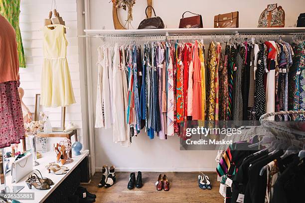 clothing and shoes for display at thrift store - clothes rack stock-fotos und bilder