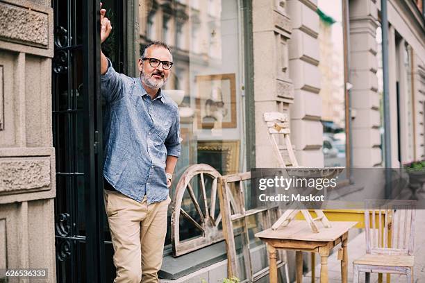 portrait of owner standing with hand on hip at antique shop - old man and glasses ストックフォトと画像