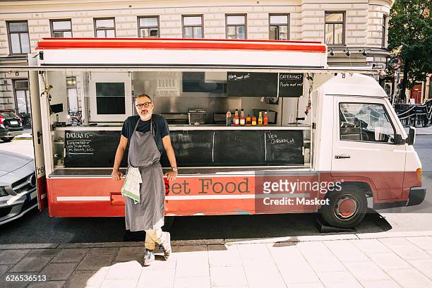 full length of male chef standing against food truck at city street - chef full length stock pictures, royalty-free photos & images