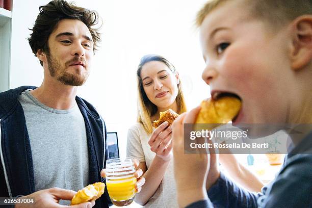 glückliche familie hat frühstück in der küche - mutter kind brot glücklich stock-fotos und bilder