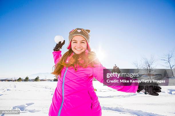 usa, utah, saratoga springs, girl (10-11) in pink jacket throwing snowball - jahreszeiten stock-fotos und bilder