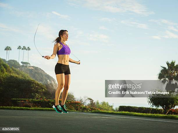 usa, california, laguna beach, young woman jumping rope in park - jump rope bildbanksfoton och bilder