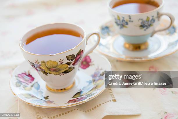 tea in tea cup on table - cup saucer stock pictures, royalty-free photos & images