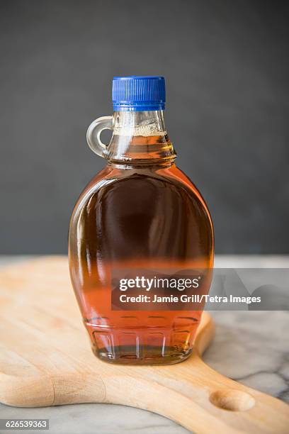 maple syrup in bottle on cutting board - maple syrup stock pictures, royalty-free photos & images