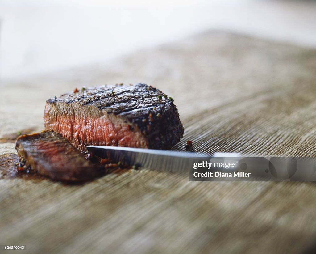 Medium rare steak with peppercorns, sliced with knife
