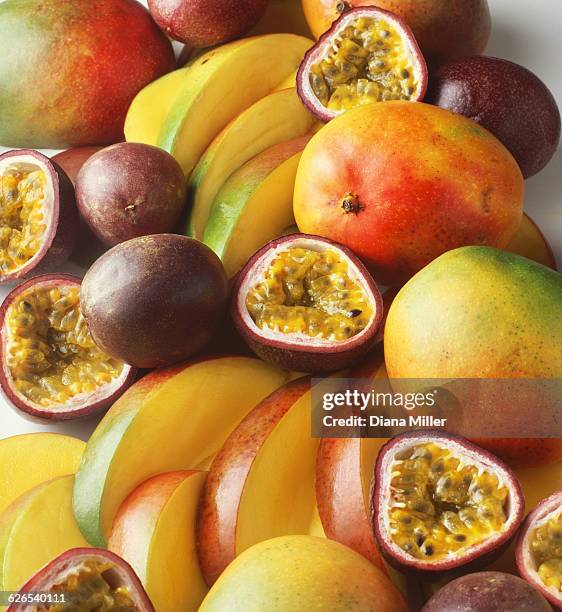 stack of tropical fruit with mangoes and passion fruit, sliced and whole - maracuja stock-fotos und bilder