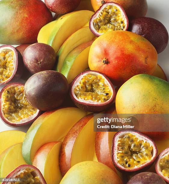 stack of tropical fruit with mangoes and passion fruit, sliced and whole - passion fruit stock pictures, royalty-free photos & images