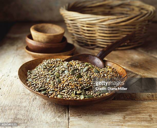 wooden bowl with pumpkin seeds, golden linseeds on hemp seeds on wooden table - hemp seed fotografías e imágenes de stock