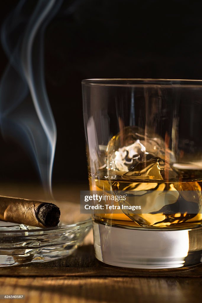 Whiskey and cigar on table