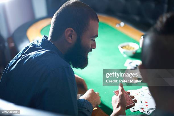 over the shoulder view of men playing card game at pub card table - card table stock pictures, royalty-free photos & images