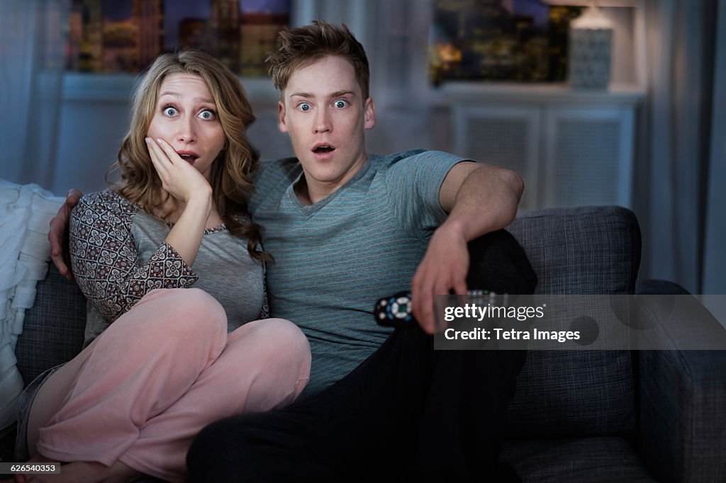 Young couple watching TV at night